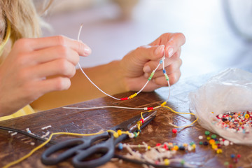 Woman making bracelet at home