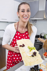 Junge Frau präsentiert eine Käseplatte