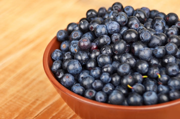 Blueberry in bowl on vintage wooden background