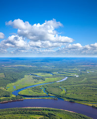 Obraz premium Forest river under white clouds, top view