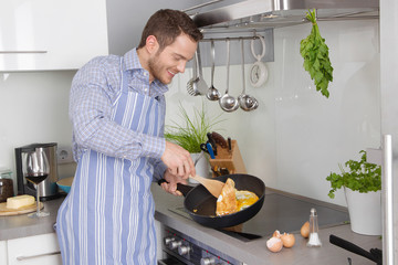 Single Mann in der Küche kocht sich ein Spiegelei