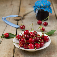 Cherries in a white plate on wooden background
