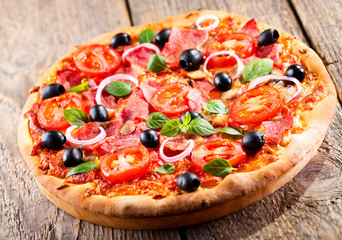 pizza with ham, olives and vegetables