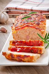 Homemade ground meatloaf with ketchup and rosemary