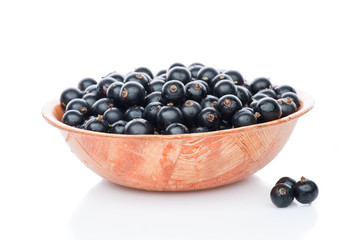 black currant in brown wooden plate