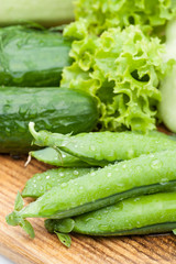 green peas pods lying with greenery