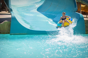 beautiful girl pulls off the slides at the water park - obrazy, fototapety, plakaty