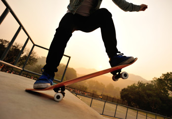 Fototapeta na wymiar woman skateboarder legs skateboarding at skatepark