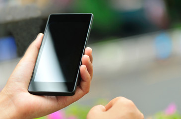 woman hand hold smart phone in modern city 