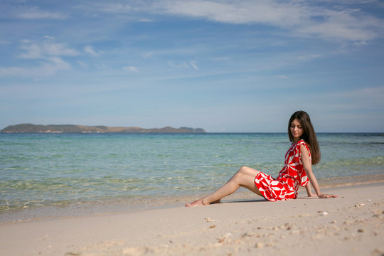 Young pretty woman in red near the sea