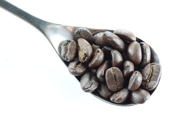 Coffee beans in a stainless steel spoon.