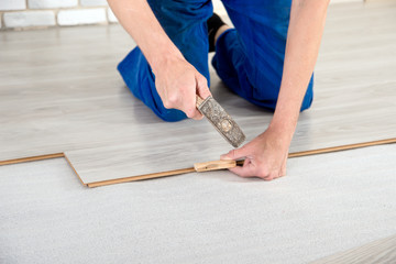 Young handsome men laid laminate floor covering, perform repairs