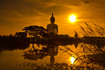 Big buddha statue at Wat Muang with sunset sky in Thailand