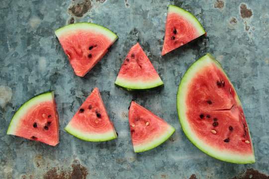 Fresh watermelon sliced in triangles on old metal board