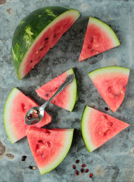 Watermelon sliced in triangle pieces on an old metal board