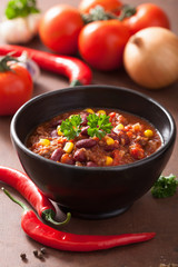 mexican chili con carne in black bowl with ingredients