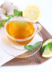 Cup of tea with ginger on napkin isolated on white