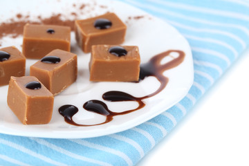 Many toffee on plate on napkin isolated on white