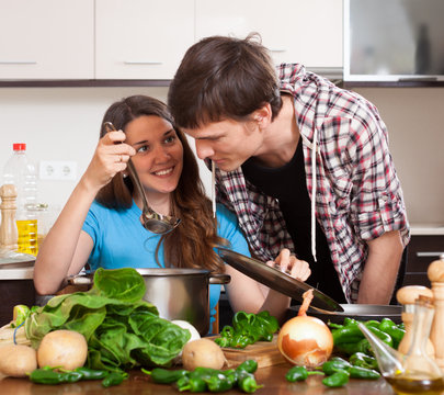 young man and the woman try the cooked food
