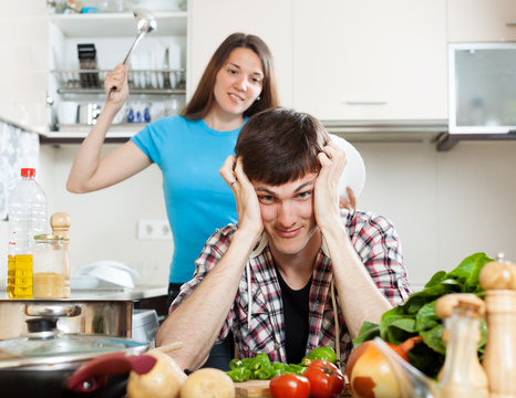 Unhappy young man with angry wife at home