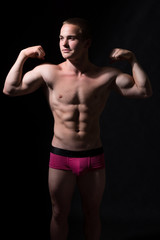 Fototapeta na wymiar Muscular guy shows biceps.