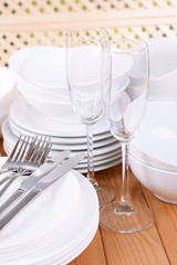 Set of white dishes on table on light background