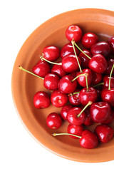 Sweet cherry on color plate isolated on white