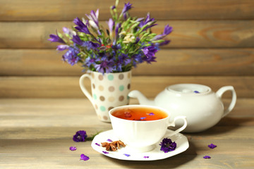 Cup of fresh herbal tea on wooden table