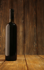 Bottle of red wine on wooden background