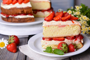 Delicious biscuit cake with strawberries on table close-up