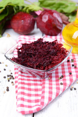 Grated beetroots in bowl on table close-up