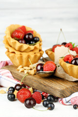 Tasty tartlets with berries on wooden table