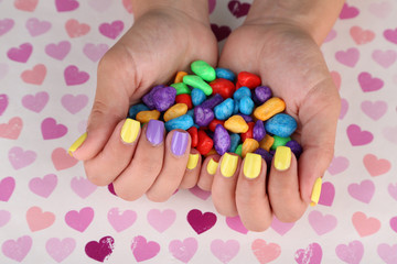 Female hand with stylish colorful nails holding colorful