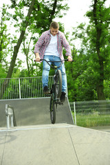 Young boy jumping with his BMX Bike at skate park