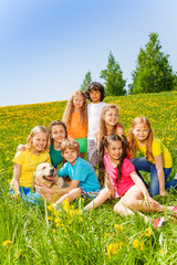 Happy children with dog together in meadow