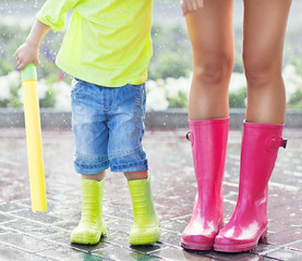 Child and mother wearing pink and green rain boots