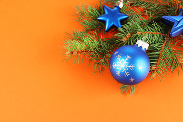 Fototapeta na wymiar Beautiful Christmas decorations on fir tree on orange