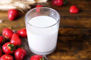 Ripe sweet strawberries and glass with milk