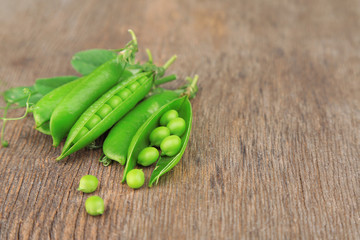 Fresh green peas on wooden table