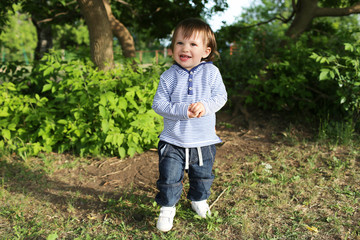 portrait of 20 months baby boy walking in summer