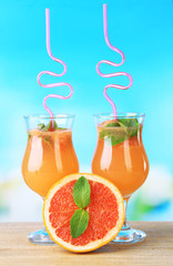 Grapefruit cocktail with cocktail straw on bright background