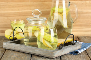 Sangria drink in glass and jar on wooden background