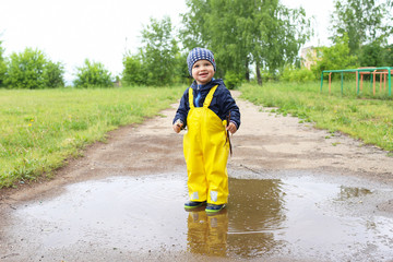 happy baby standing in puddle