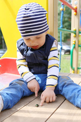 baby with beetle on playground