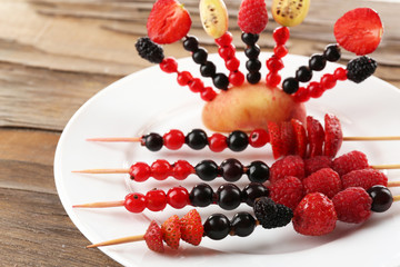 Fresh fruit kebabs for healthy snack on plate close up
