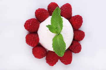 Creamy ice cream with raspberries and mint leaves isolated