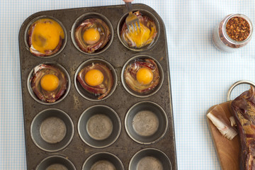 Obraz na płótnie Canvas Surowy boczek i jajka na patelni bułeczki