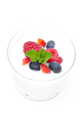 yogurt with different fresh berries and mint in a glass beaker
