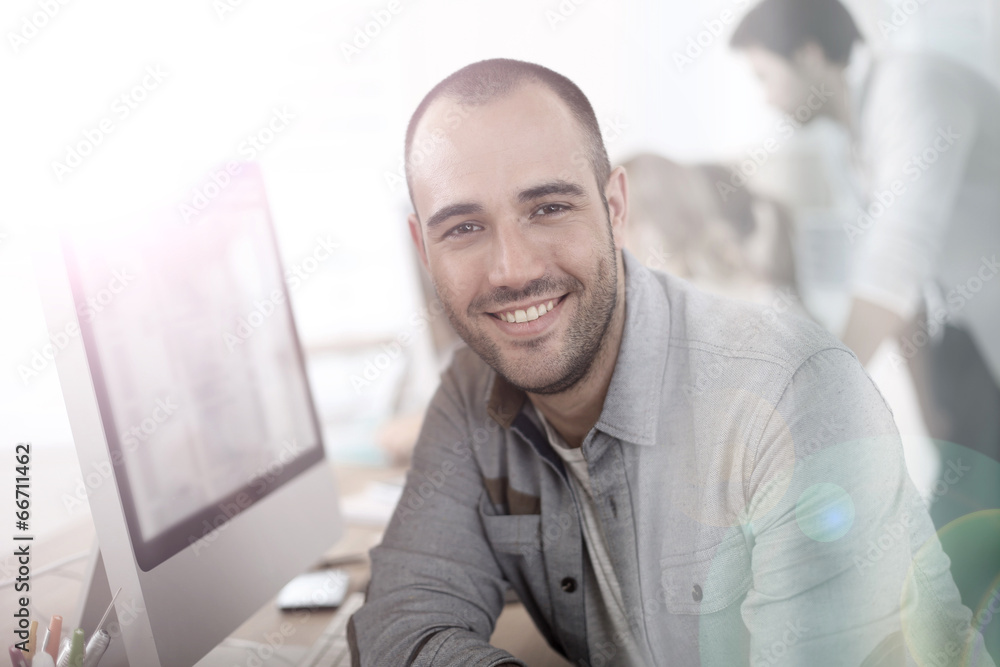 Aufkleber cheerful guy sitting in front of desktop computer