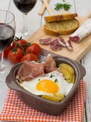 Spanish traditional dish fried eggs with serrano ham and potatoe